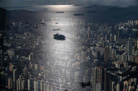 9月20日，中国香港，人们在观景台上俯瞰城市景观，窗户上映出来往船只的影像。MAY JAMES /人民视觉 图